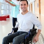 An image of a young man in a wheelchair happy to receive physiotherapy